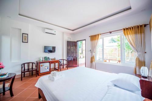 a bedroom with a white bed and a window at Trung Huynh Bungalow in Phu Quoc