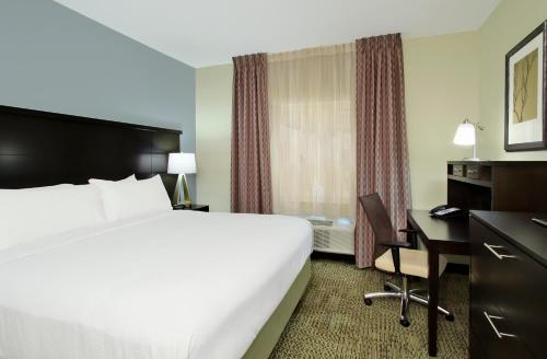 a hotel room with a bed and a desk at Staybridge Suites - Houston - Medical Center by IHG in Houston