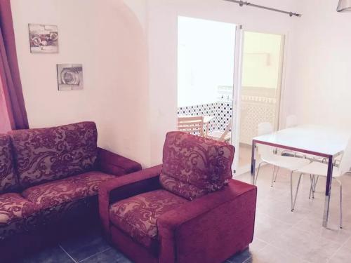 een woonkamer met een rode stoel en een piano bij Rosales Apartment with balcony by Centrall alquileres turísticos in Nerja