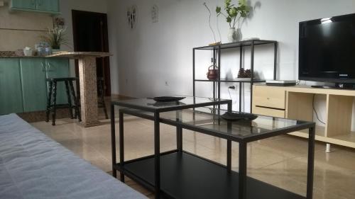 a living room with a glass table and a tv at UNION 64 in Vecindario