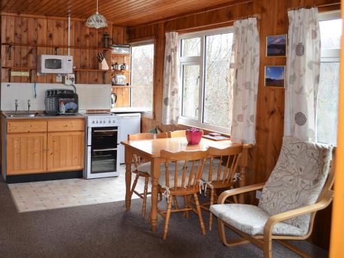 a kitchen with a table and chairs in a room at Faichemard Farm Chalets in Invergarry