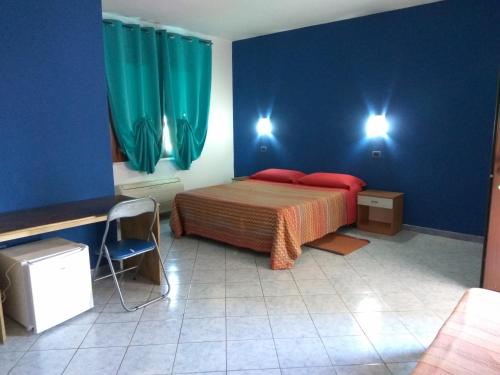 a bedroom with a bed with blue walls and red pillows at Entula in Àrbatax