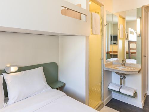 a bedroom with a bed and a bathroom with a sink at ibis budget RJ Praia de Botafogo in Rio de Janeiro