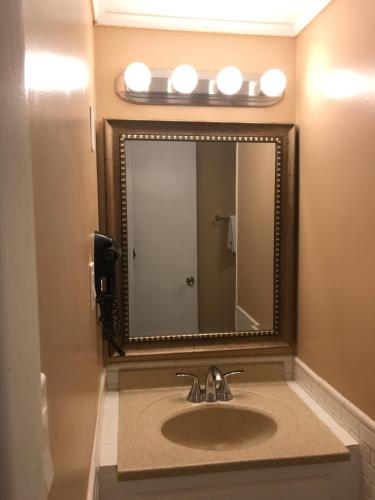 a bathroom with a sink with a large mirror at Moonlite Motel in Niagara Falls
