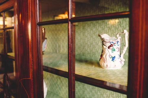 a vase sitting on a shelf behind a glass door at Causeway Hotel in Bushmills