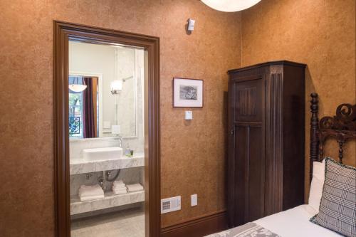 a bathroom with a bed and a sink and a mirror at Monte Cristo Bed and Breakfast in San Francisco