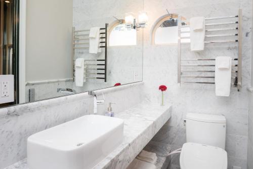 a white bathroom with a sink and a toilet at Monte Cristo Bed and Breakfast in San Francisco