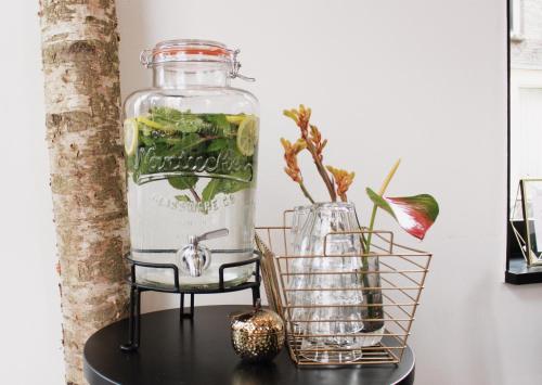 a jar of water and a vase on a table at Linden Hotel in Amsterdam