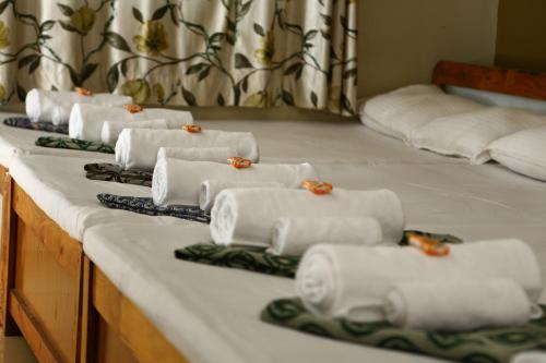 a row of white towels sitting on top of a table at Atithi Lodge in Ganpatipule