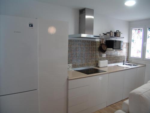 a white kitchen with a sink and a microwave at Pialmont House in Marbella