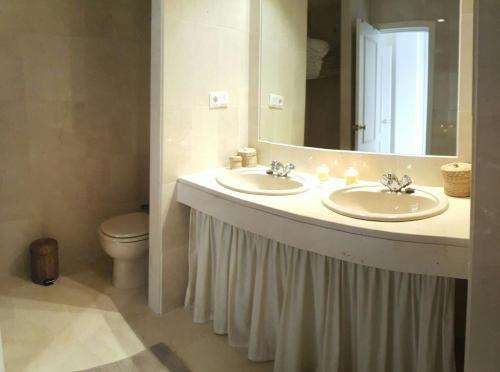エステポナにあるApartamento del Solのバスルーム(洗面台2台、鏡、トイレ付)