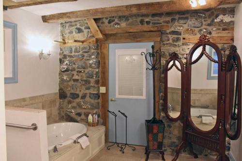 a bathroom with a tub and a large mirror at Gettysburg Battlefield Bed & Breakfast Inn in Gettysburg