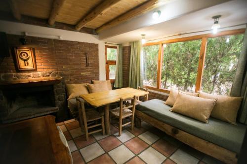 a living room with a couch and a table at Carü Leufu in Valle Grande