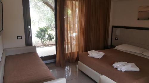 a hotel room with two beds and a window at Park Hotel Cilento in Marina di Camerota