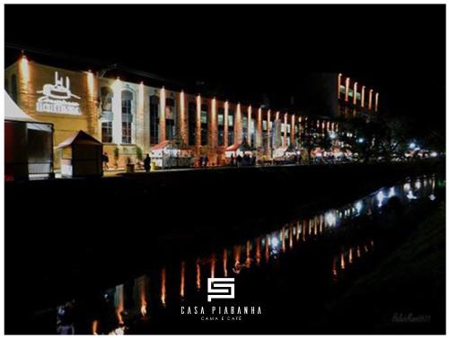 a night view of a city with buildings and a body of water at Casa Piabanha - Centro Histórico in Petrópolis