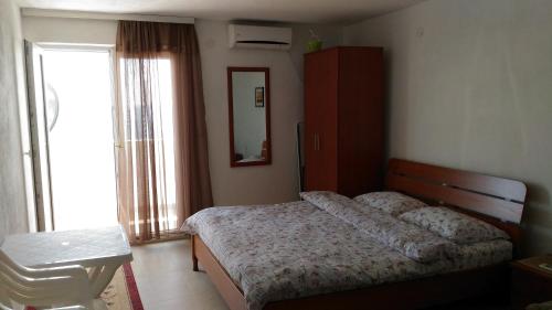 a bedroom with a bed and a table and a mirror at Apartment Boksi in Ulcinj