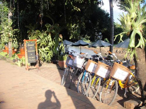 a group of bikes parked on a sidewalk with umbrellas at Luang Prabang Nagara Villa River View in Luang Prabang
