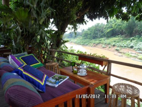 a porch with a couch and a table and a river at Luang Prabang Nagara Villa River View in Luang Prabang