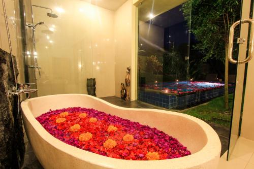 a bath tub filled with flowers in a bathroom at AS Resort in Ubud