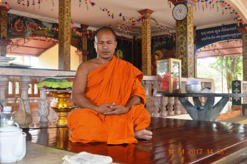 a monk sitting on a table in a temple at Sok Phen Homestay in Siem Reap