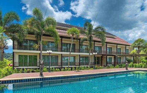 a hotel with a swimming pool in front of a building at Krabi Home Town Boutique in Krabi town