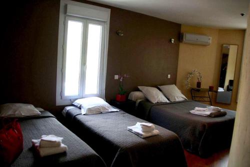 a room with two beds with towels on them at L'Avenue in Agde