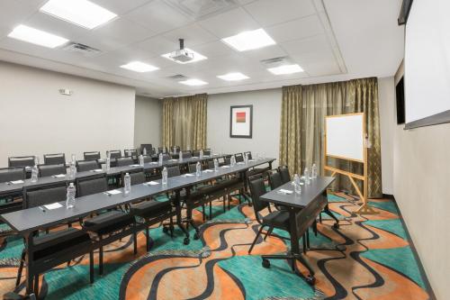 a conference room with tables and chairs and a whiteboard at Wingate by Wyndham Lubbock in Lubbock