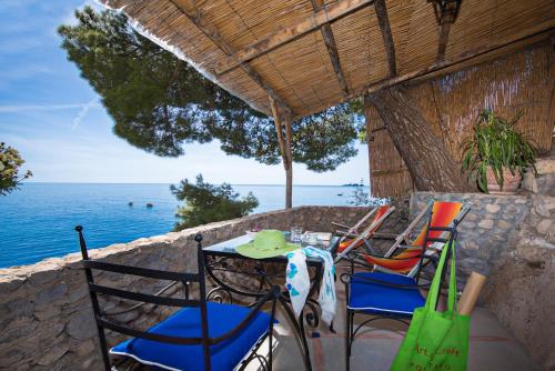 a table and chairs on a patio with a view of the ocean at Villa Torre Trasita luxury suites in Positano