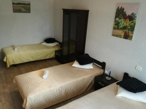 a room with three beds and a mirror at Kalbakas Apartamenti in Smiltene