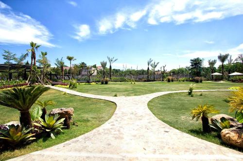 a walking path in a park with palm trees at MaxOneHotels at Resort Makassar in Makassar