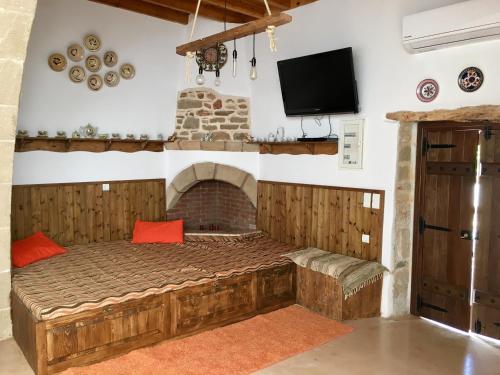 アルハンゲロスにあるAnemos Traditional Villaのベッドルーム(ベッド1台、暖炉、テレビ付)