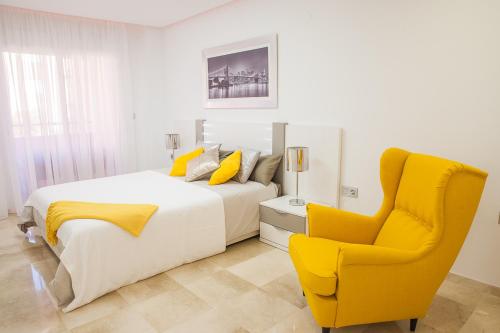 ベナルマデナにあるLuxury 100 sq.m. sea view apartmentのベッドルーム1室(ベッド2台、黄色い椅子付)