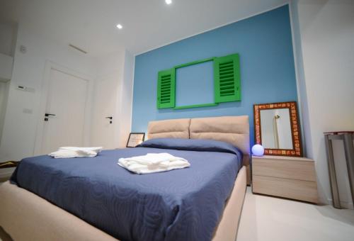 a blue bedroom with a bed and a mirror at B&B Mareè Seafront Molfetta in Molfetta
