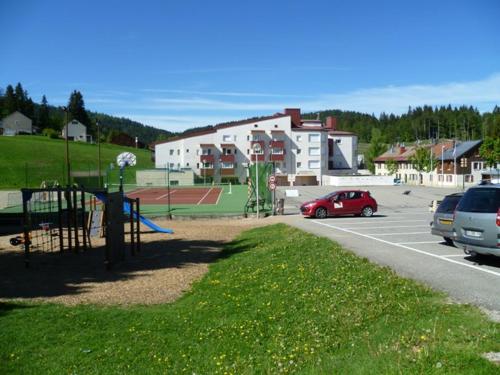 a car parked in a parking lot with a playground at La Serre Nelly Philippe in Prémanon