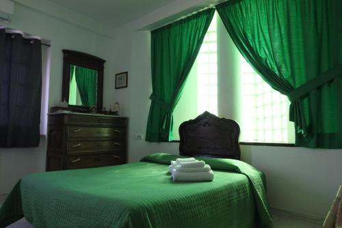 una camera con letto verde, cassettiera e finestra di Mezzabrino Vista Castello a Itri