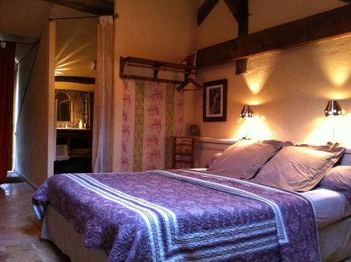 - une chambre avec un lit et une couverture violette dans l'établissement La chapelle du Domaine, à Saint-Loup-Géanges