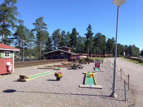 a park with a playground with benches and slides at Ljusdals Camping in Ljusdal