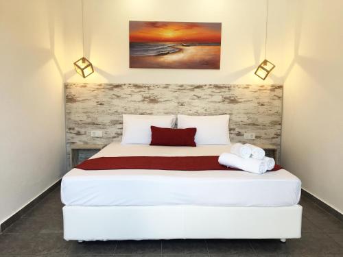 a bedroom with a white bed with two towels on it at Anemos Studios in Adamas