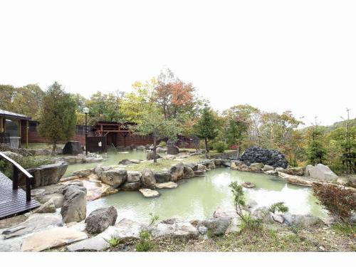 a pool of water with rocks in a park at Niseko Grand Hotel in Niseko