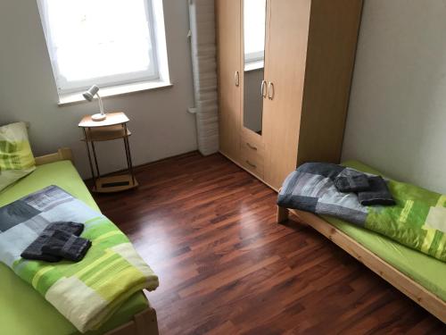 a room with two beds and a wooden floor at Haus Johanna in Lechbruck