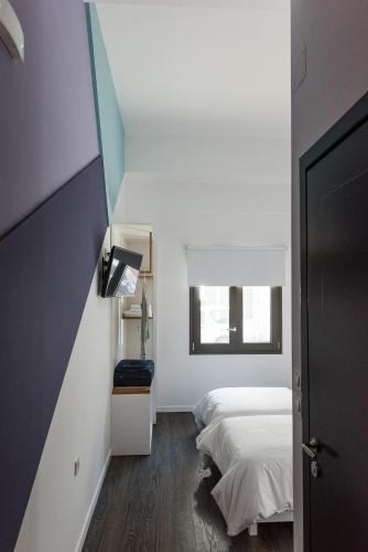 a small bedroom with a bed and a window at Cocoon City Hostel in Chania Town