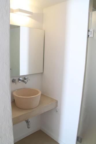 a bathroom with a bowl sink and a mirror at S'Esparteria Hotel in Ciutadella