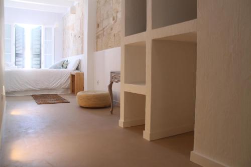 a room with a bed and a room with a book shelf at S'Esparteria Hotel in Ciutadella