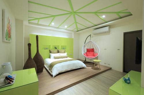 1 dormitorio con cama y silla colgante en Early Summer, en Luodong