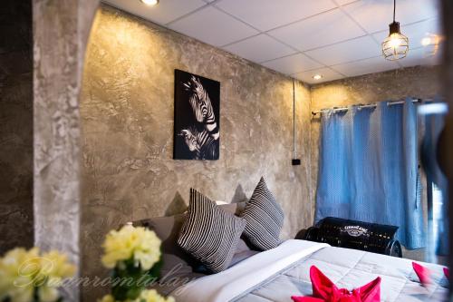- une chambre avec un lit fleuri dans l'établissement Baan Rom Talay, à Ko Samet