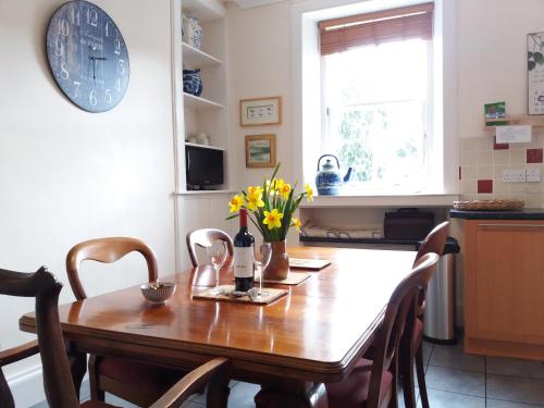 a kitchen with a wooden table with yellow flowers on it at Abbey View in Kelso
