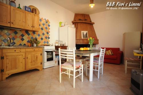 a kitchen with a table and chairs and a refrigerator at Fiori e Limoni in Quartucciu
