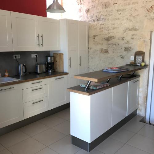 une cuisine avec des armoires blanches et un comptoir dans l'établissement Le Domaine des Ramonets, à Cahors