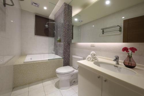 a bathroom with a toilet and a sink and a tub at Early Summer in Luodong