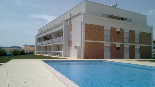 een gebouw met een zwembad voor een gebouw bij Carmona G in São Martinho do Porto